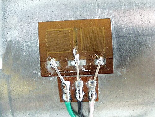 A foil strain gauge — close-up showing the zigzag conductor pattern